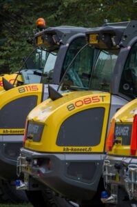 Close-up of yellow Kramer wheel loaders parked in a row, outdoors in Lepaa, Finland.